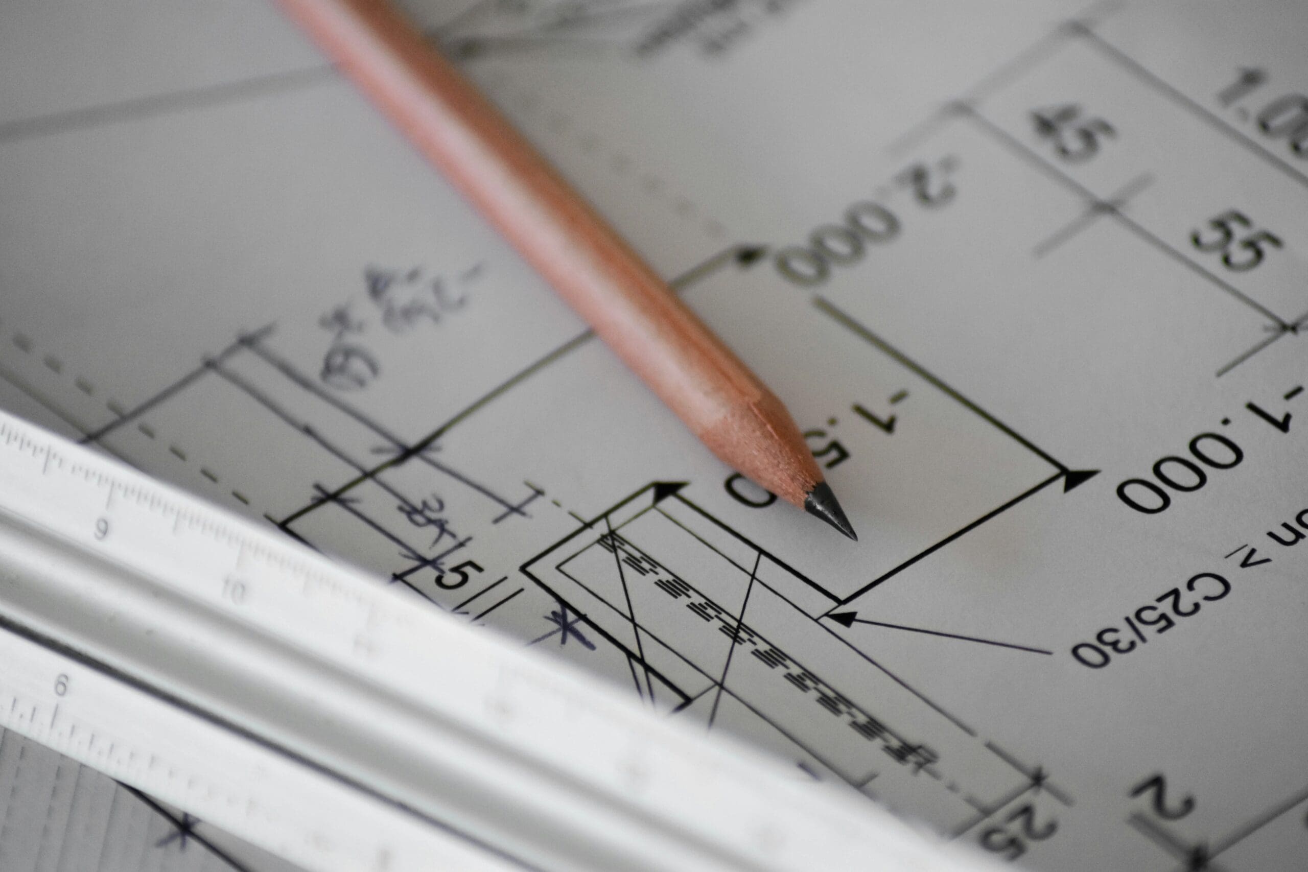 Detailaufnahme einer Architekturzeichnung mit Bleistift und Lineal – Symbol für die Planung von Raumkonzepten, Renovierung und Einrichtung. Ideal als Titelbild für Themen rund um Parkett, Malerarbeiten und Interior Design.